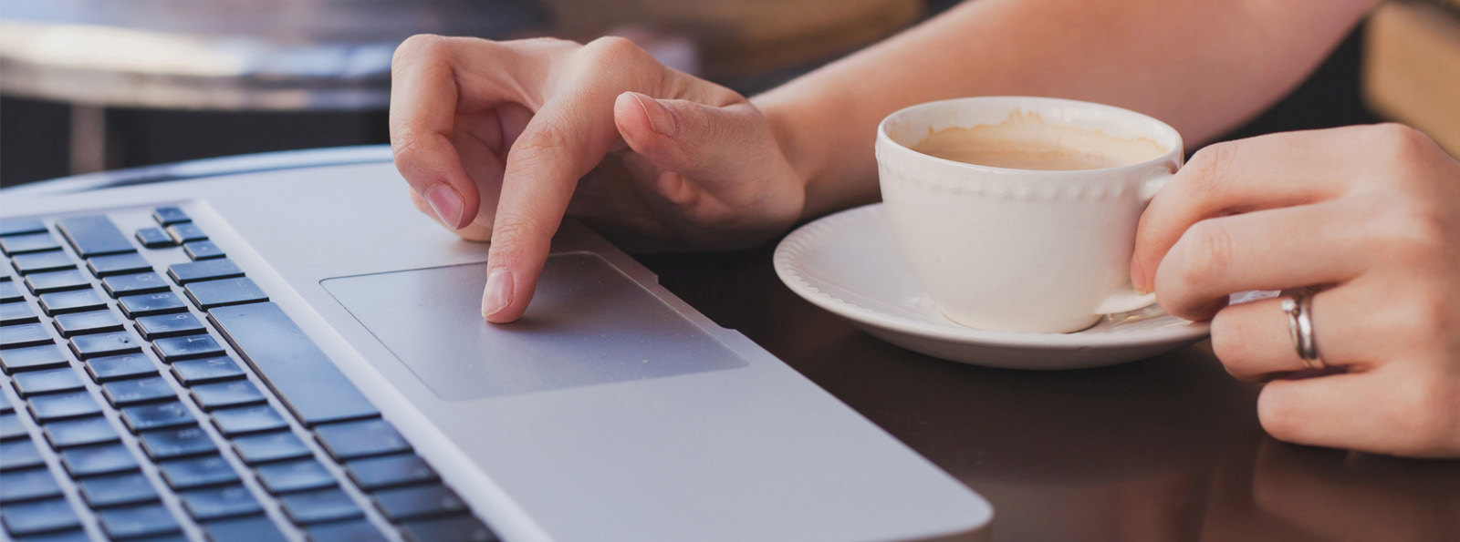 woman working on computer while drinking coffee