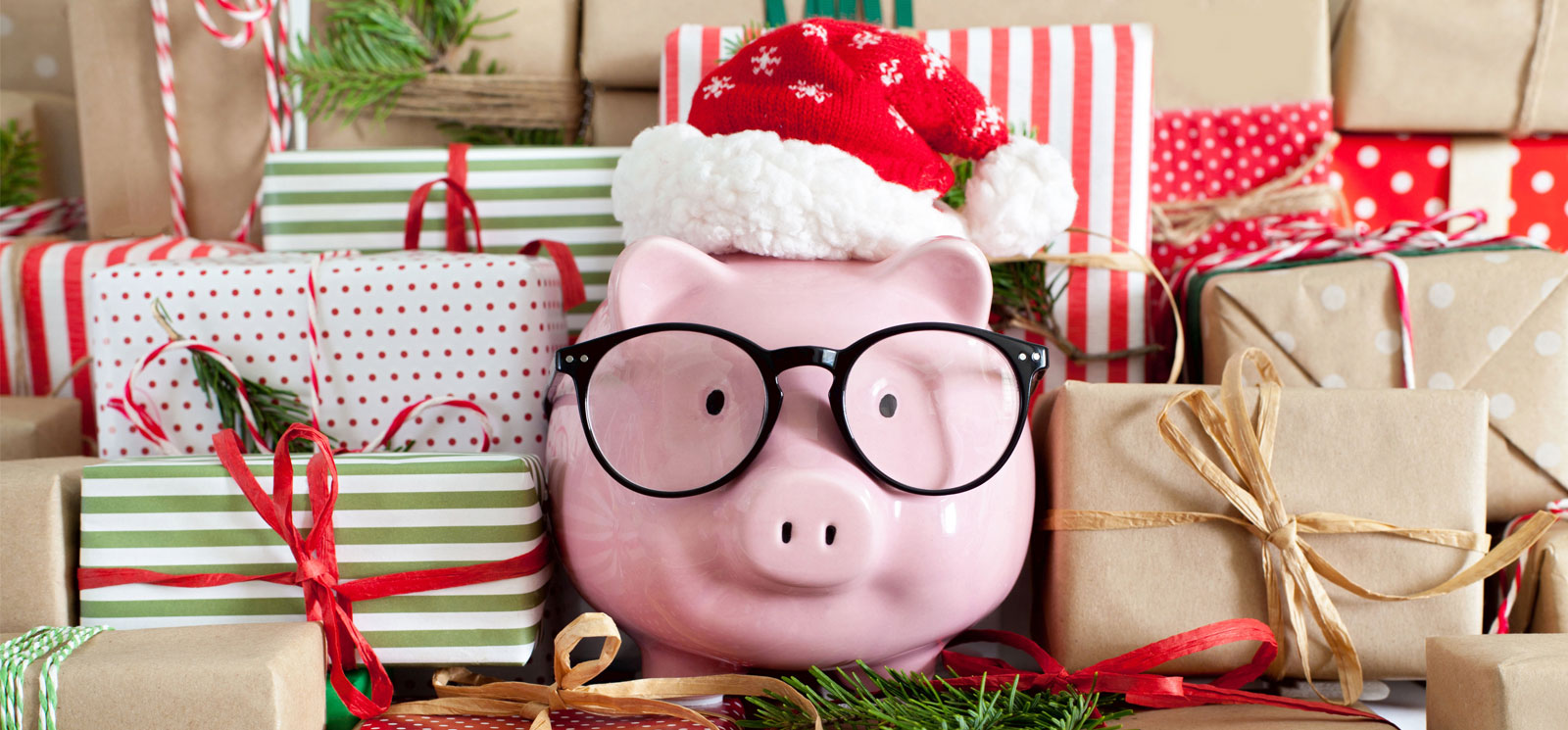 piggy bank with santa hat and glasses surrounded by gifts