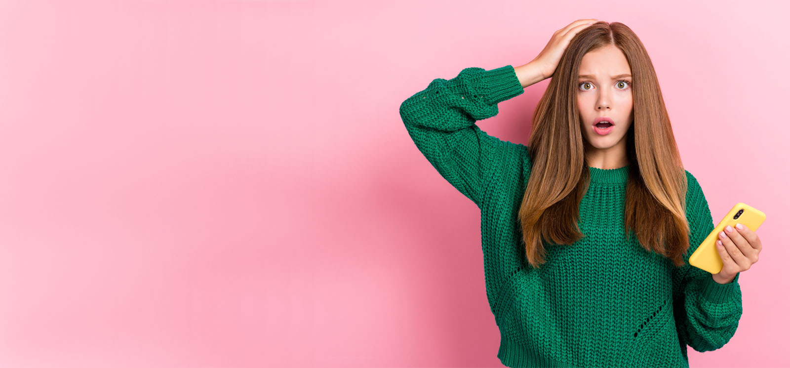teenage girl holding smartphone with worried look and hand on head